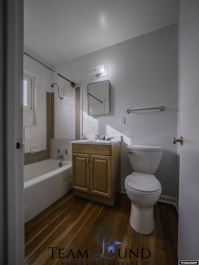 full bathroom with tiled shower / bath, wood-type flooring, toilet, and vanity