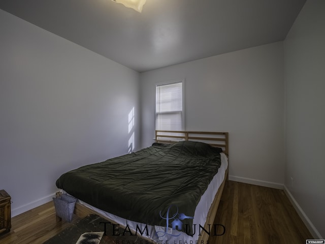 bedroom with dark hardwood / wood-style floors