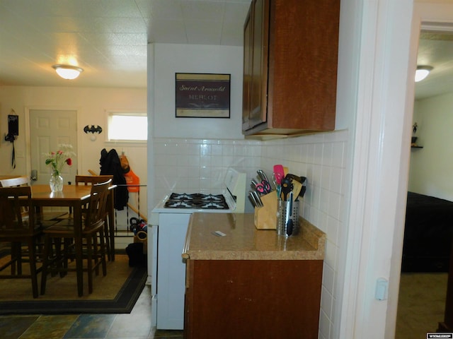 kitchen featuring tasteful backsplash and white gas stove