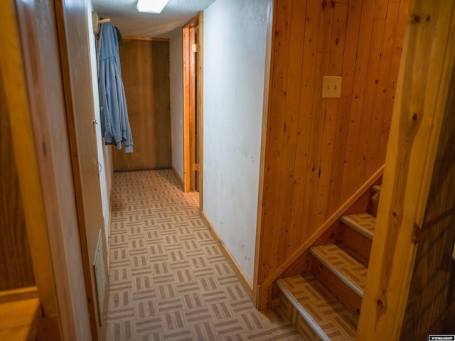 corridor with light parquet flooring and wooden walls