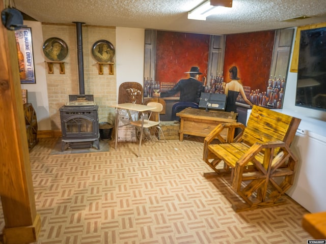 living area featuring light parquet floors, a wood stove, and a textured ceiling