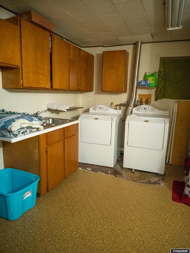 laundry area featuring cabinets, washing machine and clothes dryer, and sink