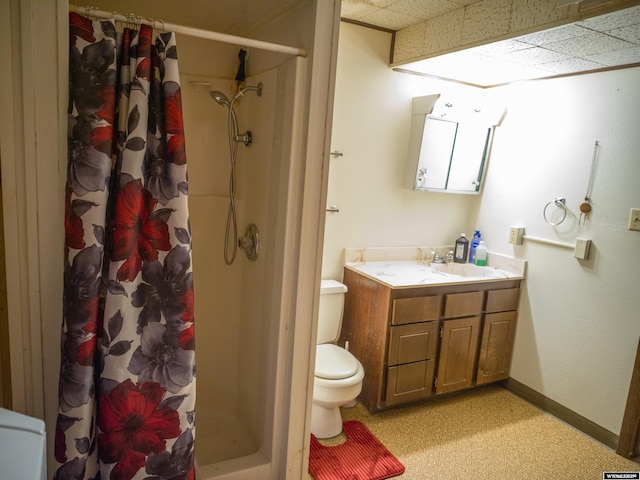 bathroom with vanity, toilet, curtained shower, and a drop ceiling