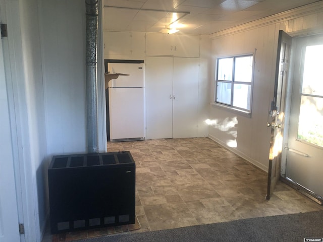 interior space with wood walls, plenty of natural light, and a wood stove