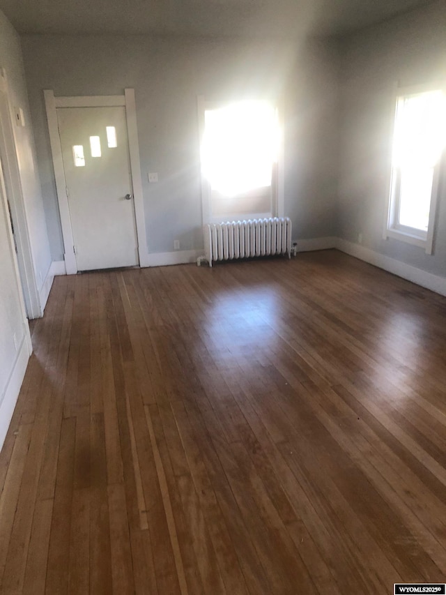 interior space featuring radiator, baseboards, and dark wood-style flooring