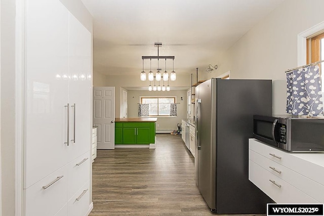 kitchen featuring pendant lighting, hardwood / wood-style flooring, green cabinets, appliances with stainless steel finishes, and white cabinets