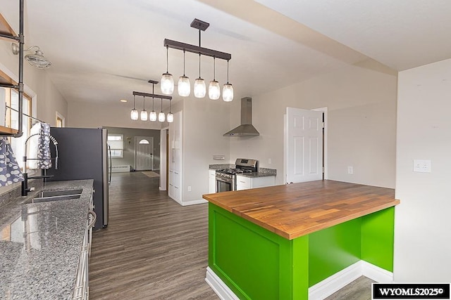 kitchen featuring dark wood-type flooring, wood counters, stainless steel range with gas stovetop, green cabinets, and wall chimney range hood