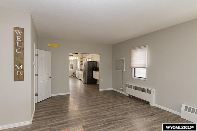 interior space with dark wood-type flooring and radiator heating unit