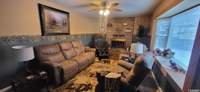 living room with a stone fireplace and a ceiling fan