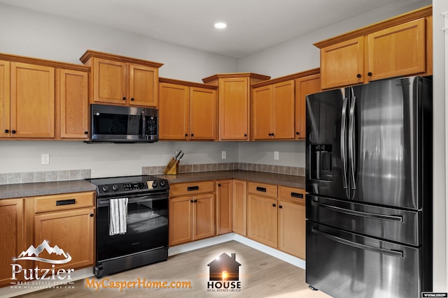 kitchen with range with electric cooktop, stainless steel fridge, and light hardwood / wood-style floors