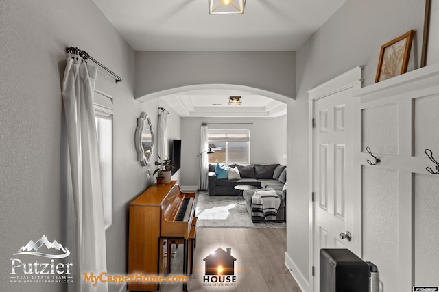 hall featuring a tray ceiling and hardwood / wood-style floors