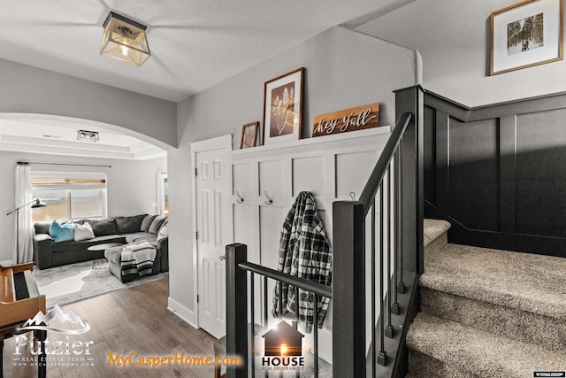 staircase featuring hardwood / wood-style floors and a textured ceiling