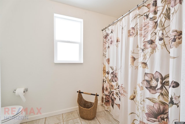 bathroom with tile patterned floors, toilet, and walk in shower