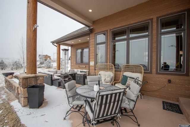 snow covered patio featuring an outdoor living space