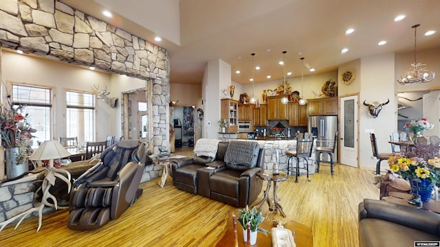 living room featuring light hardwood / wood-style floors, a high ceiling, and a chandelier