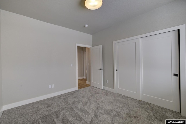 unfurnished bedroom featuring light carpet and a closet