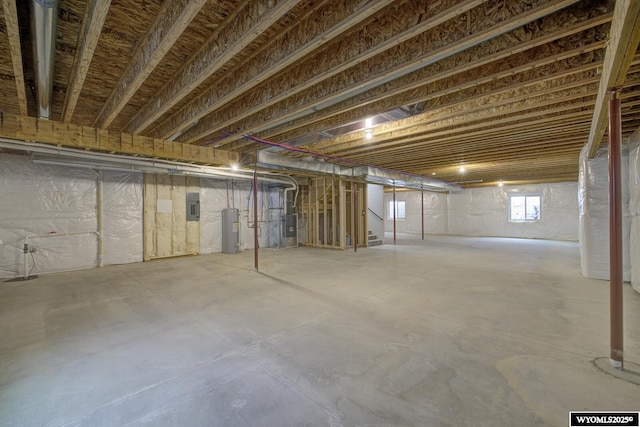 basement featuring electric panel and water heater