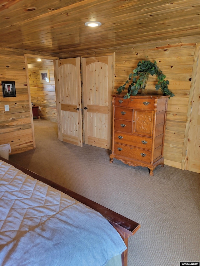 bedroom with carpet, wooden walls, and wood ceiling