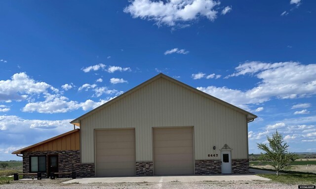 6447 Clark Cir, Torrington, WY 82240 - view of side of home with a garage, stone siding, and an outdoor structure