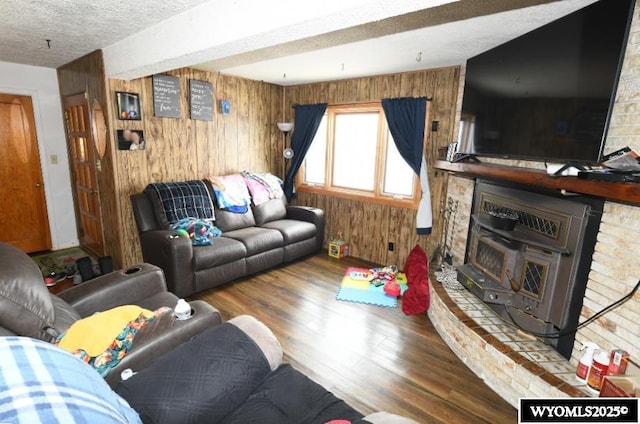 living room featuring hardwood / wood-style flooring, wood walls, and a textured ceiling