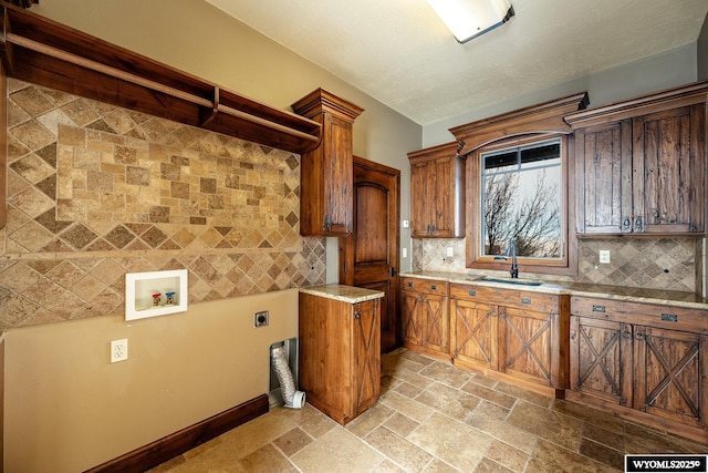 kitchen featuring sink, light stone counters, and tasteful backsplash