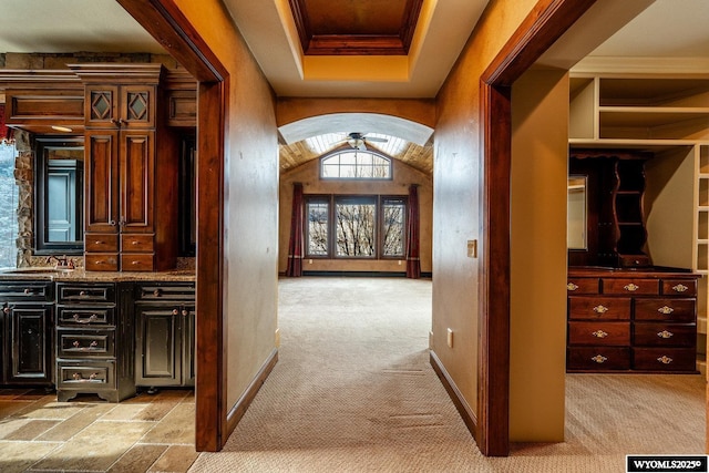 corridor featuring light carpet and lofted ceiling