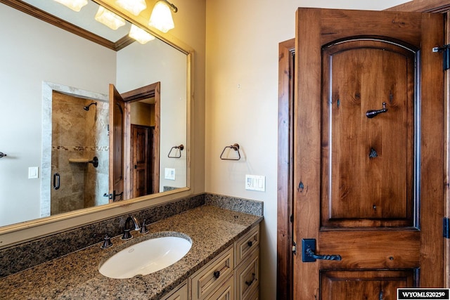 bathroom with vanity, crown molding, and a tile shower