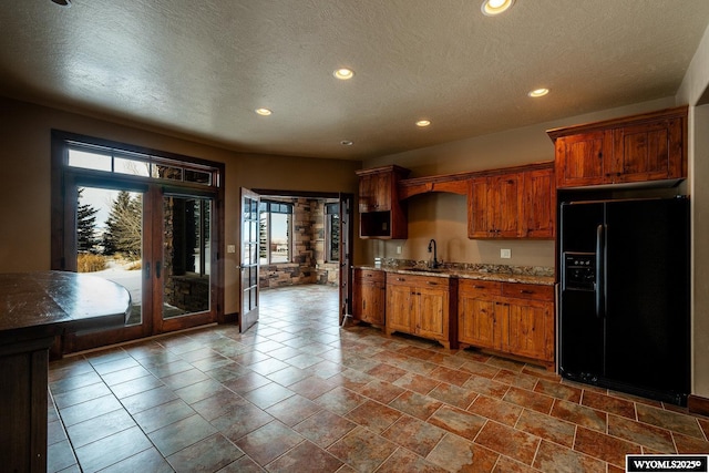 kitchen featuring sink, french doors, black fridge with ice dispenser, and a textured ceiling