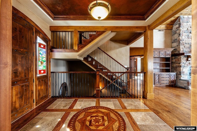 entrance foyer with hardwood / wood-style floors, a tray ceiling, and ornamental molding