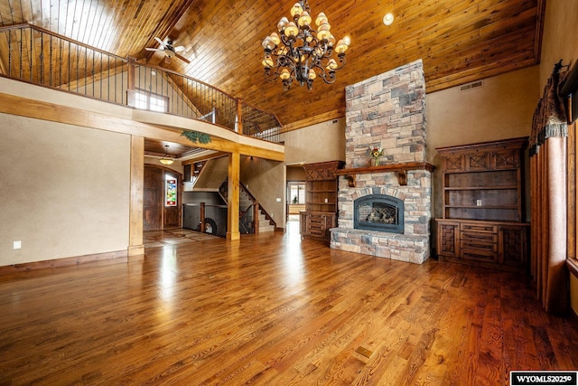 unfurnished living room featuring high vaulted ceiling, hardwood / wood-style flooring, wooden ceiling, and a fireplace