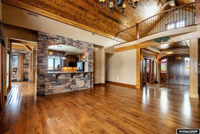 unfurnished living room with wood ceiling, an inviting chandelier, and hardwood / wood-style floors