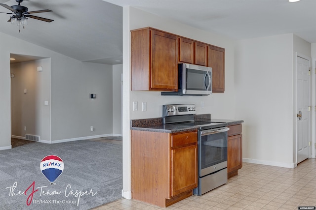 kitchen featuring appliances with stainless steel finishes, ceiling fan, vaulted ceiling, and light colored carpet