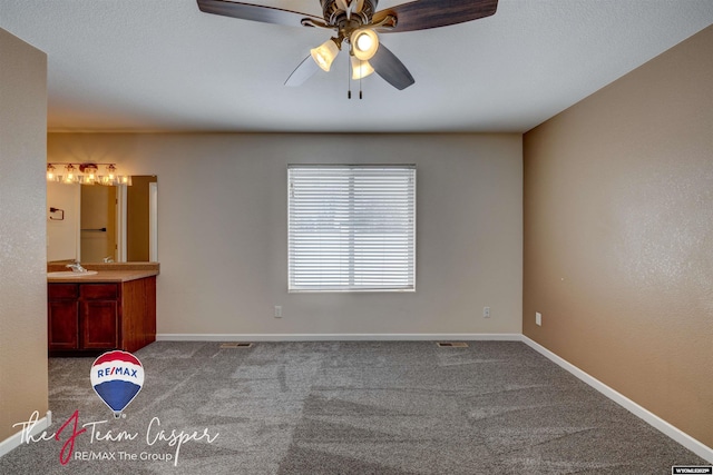 carpeted spare room featuring sink and ceiling fan