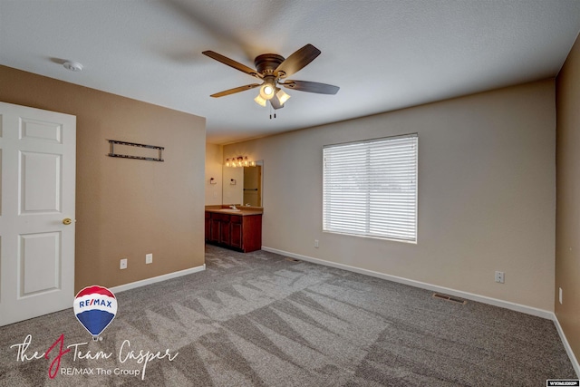 unfurnished bedroom featuring light carpet, ensuite bathroom, and sink