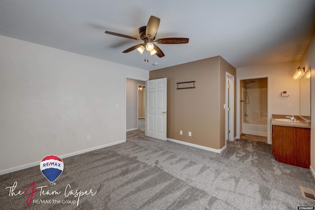 unfurnished bedroom featuring sink, carpet, and ensuite bath