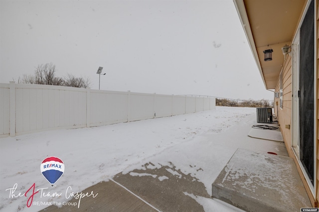 yard layered in snow featuring central AC unit