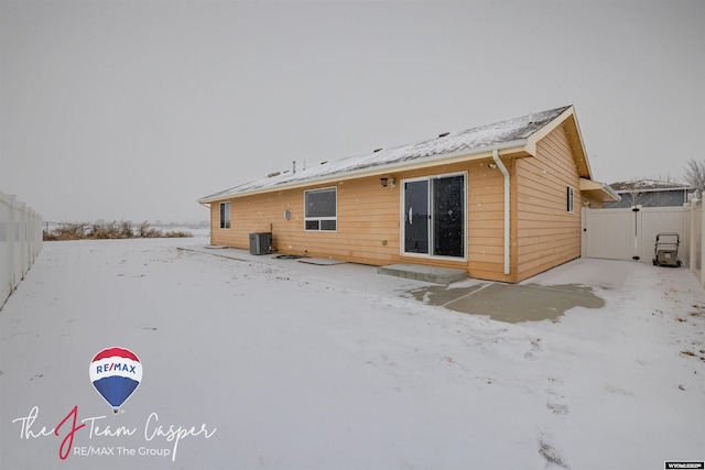 snow covered property featuring central AC unit