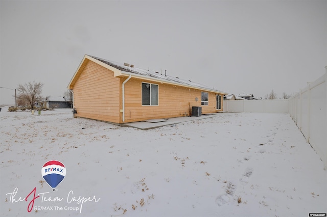 snow covered back of property with cooling unit