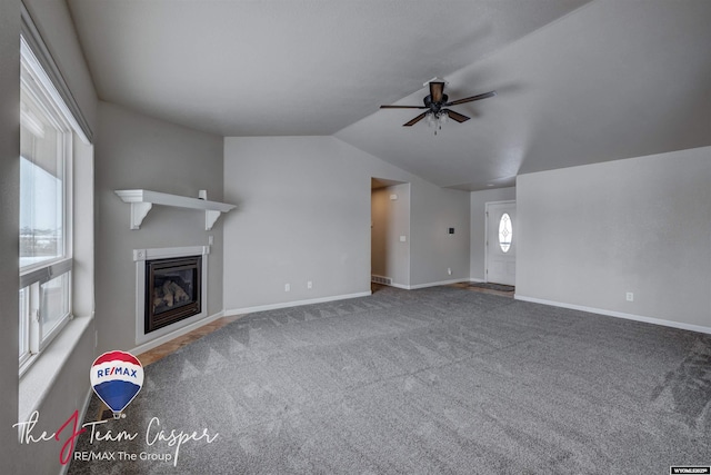 unfurnished living room featuring ceiling fan, carpet flooring, and lofted ceiling