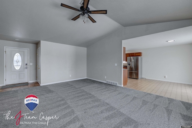 unfurnished living room with ceiling fan, light colored carpet, and lofted ceiling