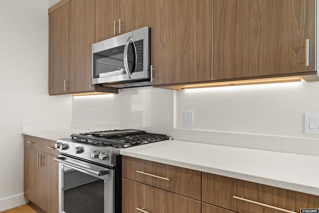 kitchen with brown cabinetry, modern cabinets, and stainless steel appliances