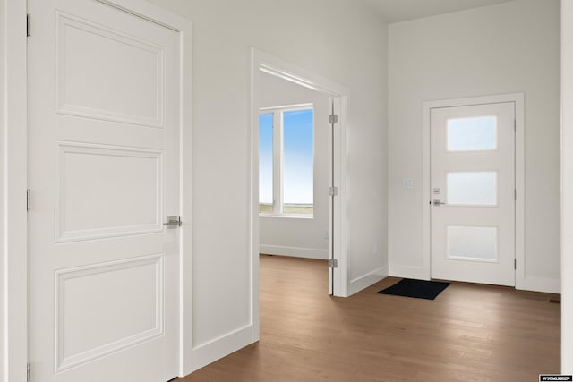 foyer with wood finished floors and baseboards