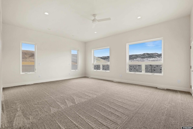 unfurnished room with carpet floors, a wealth of natural light, baseboards, and recessed lighting