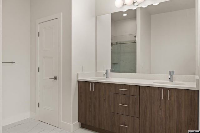 bathroom with baseboards, marble finish floor, a sink, and a shower stall