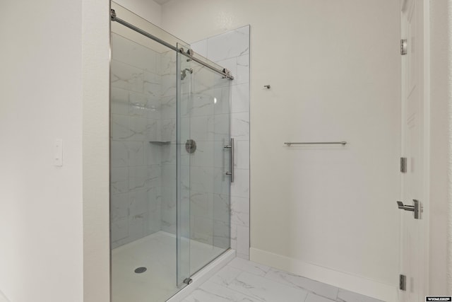 full bath with marble finish floor, baseboards, and a marble finish shower