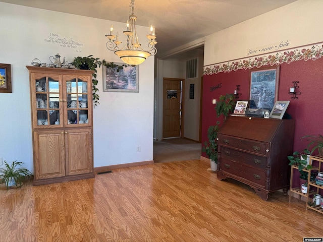 dining room featuring light wood-type flooring and an inviting chandelier