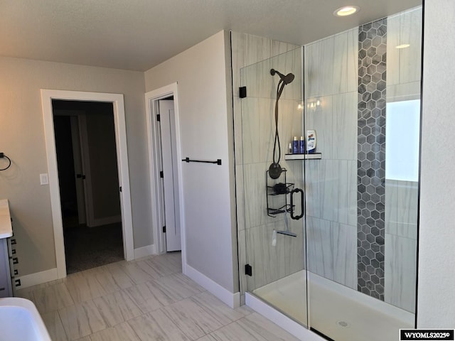 full bath with a shower stall and baseboards