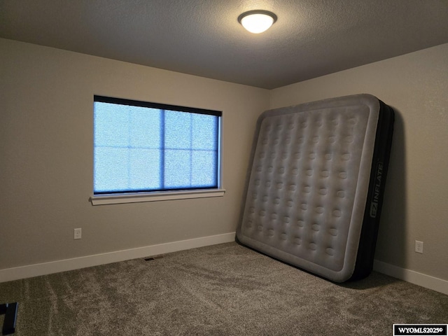 interior space with a textured ceiling and baseboards