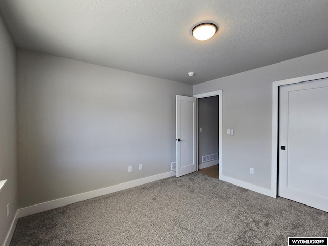 unfurnished bedroom featuring carpet floors, baseboards, visible vents, and a textured ceiling