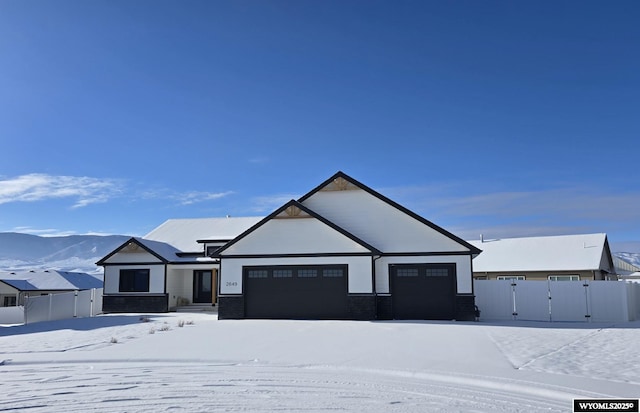 view of front of home with an attached garage, fence, and a gate